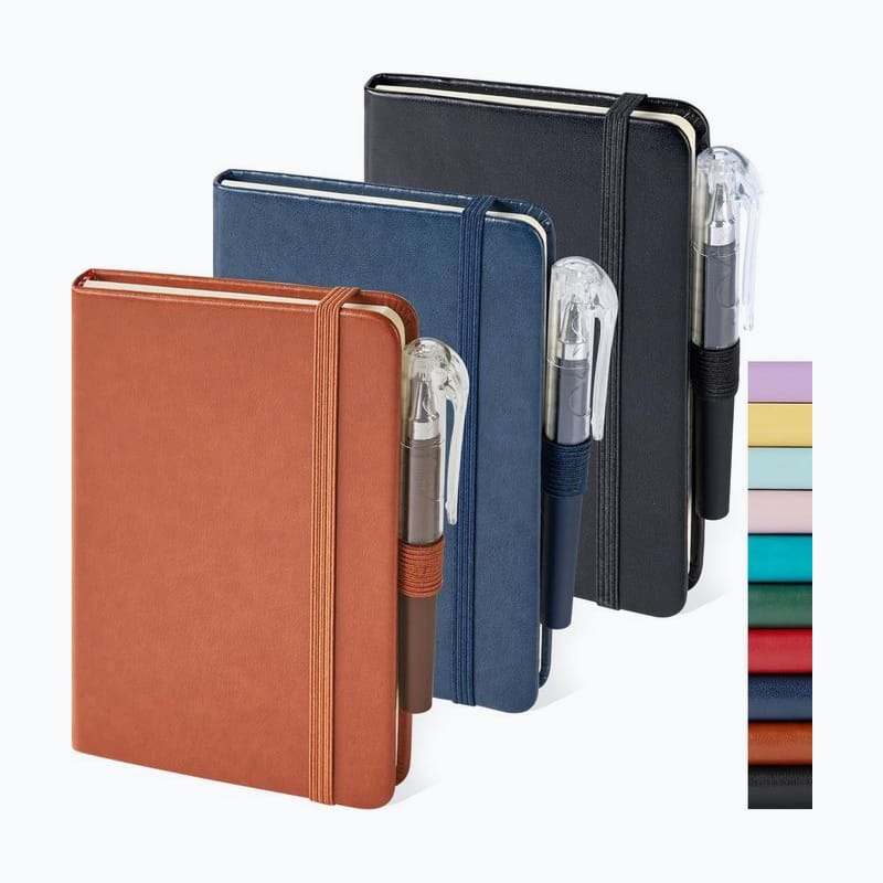 Three pocket notebooks in brown, navy, and black, each with a pen