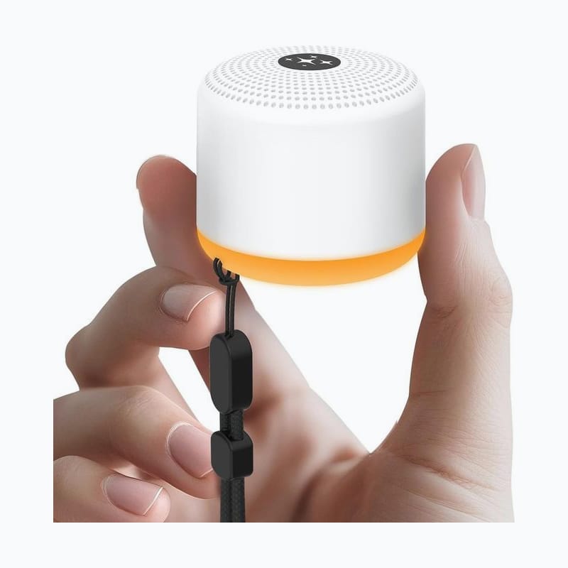 Small white noise machine held in one hand