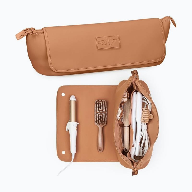 Tan heat-resistant travel pouch opened on its mat, holding a curling iron and a brush